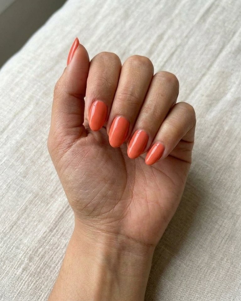 Vivid coral-orange polish on a sample hand: Bright Spring